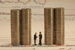 A couple of men standing next to stacks of coins

AI-generated content may be incorrect.