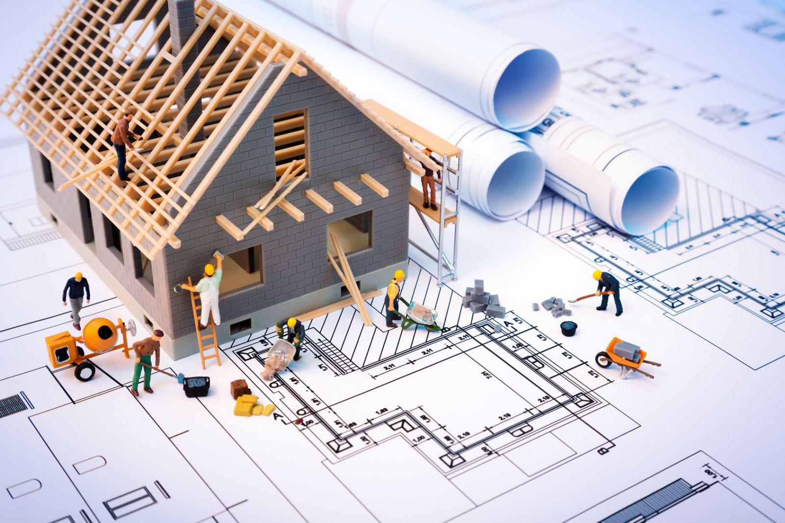 A miniature people building a house
Description automatically generated