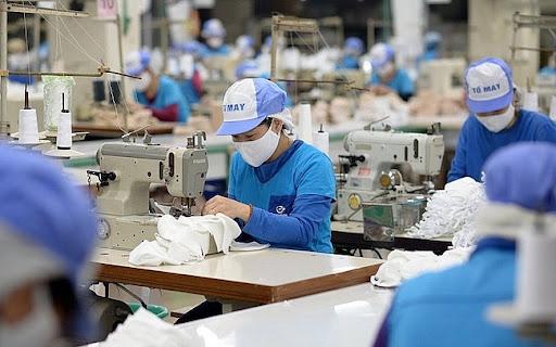 A group of people sewing on a sewing machine

Description automatically generated