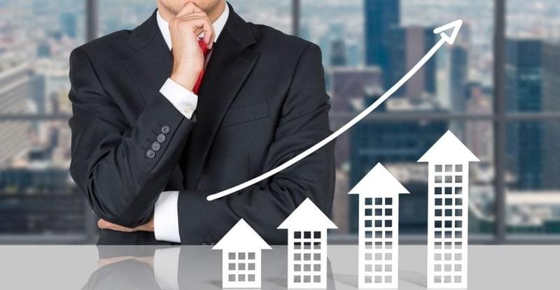 A person in a suit with his hand on his chin
Description automatically generated